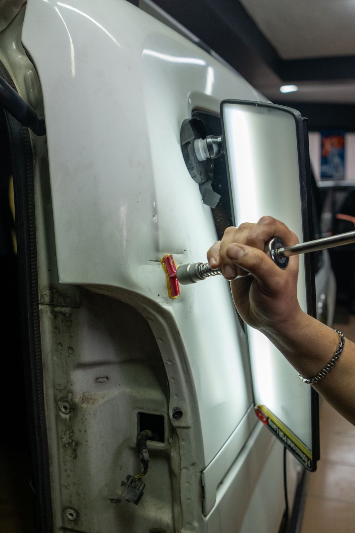 Dent repair tool being used on a vehicle panel